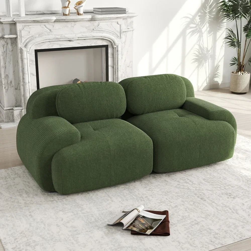 Modern green corduroy loveseat sofa in stylish living room with marble fireplace and decor